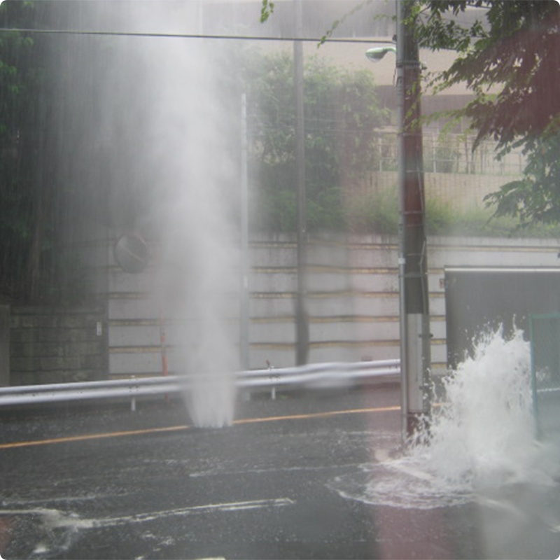 マンホールから水が噴き出している様子